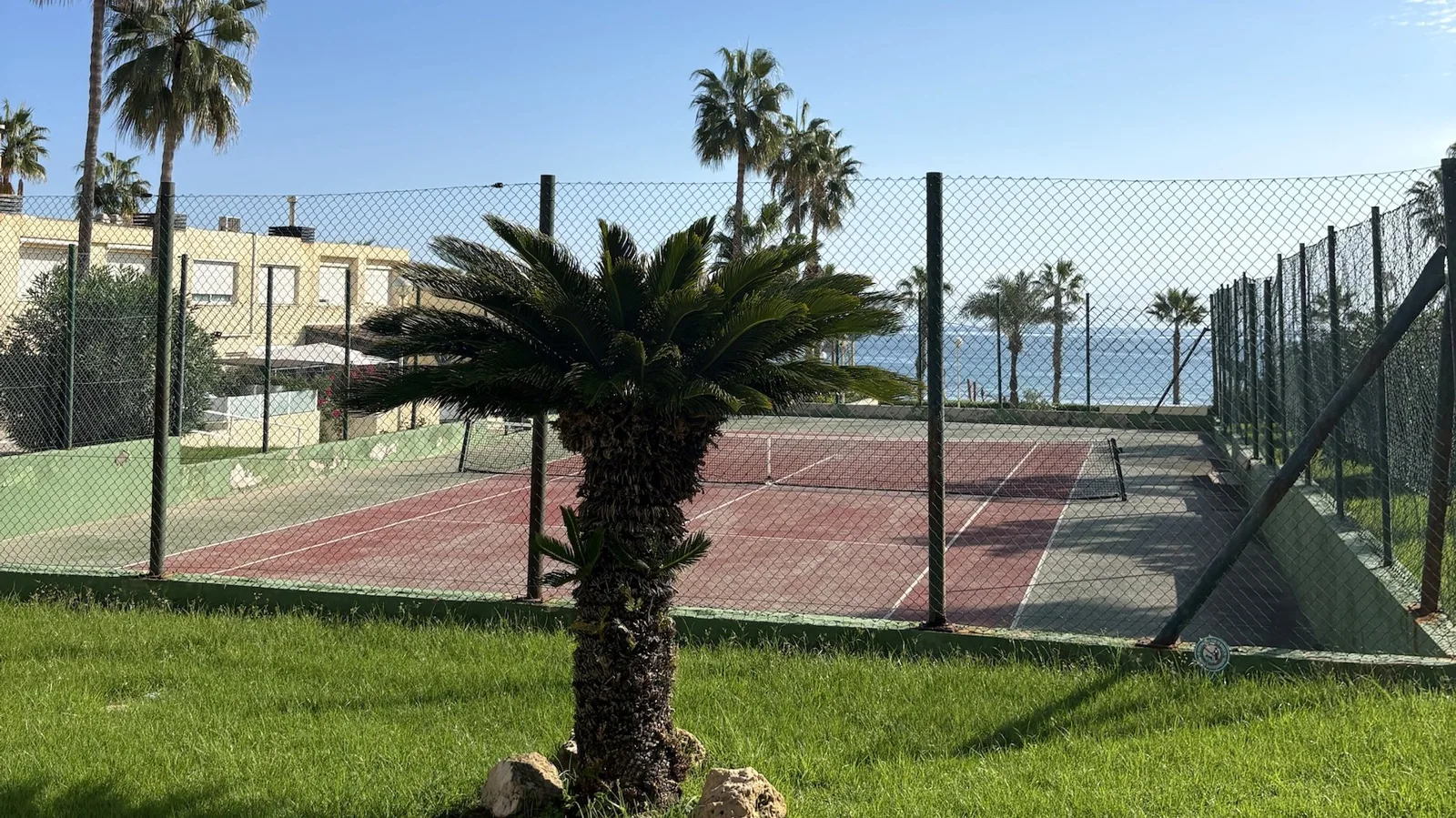 Community tennis court beside the sea